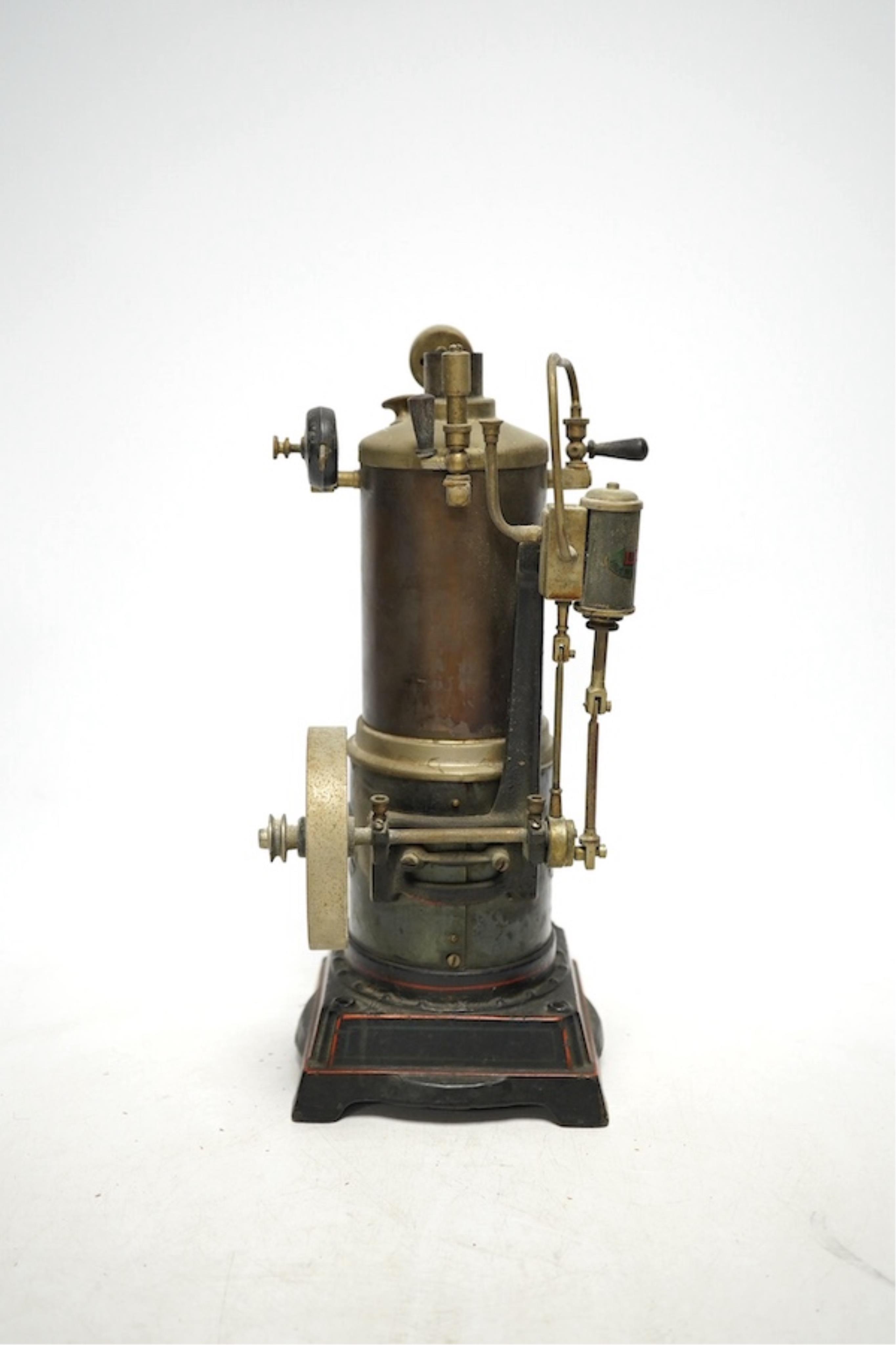 A Doll and Co. tinplate vertical boiler live steam single cylinder stationary engine, 26cm high. Condition - fair